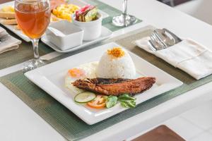 een bord met rijst en vlees op een tafel bij Hotel Canelsa in Tacloban