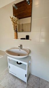 ein Bad mit einem Waschbecken und einem Spiegel in der Unterkunft La Maison d'Elise, 3 chambres, maison de caractère in Plassac