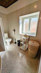 a bathroom with a toilet and a chair and a window at La Maison d'Elise, 3 chambres, maison de caractère in Plassac +24 photos