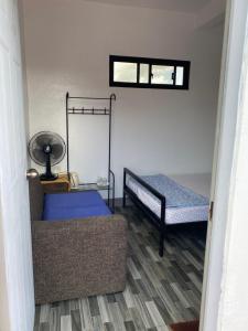 Chillax Inn في تاجيتاي: غرفة معيشة مع أريكة وسرير