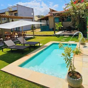 a swimming pool in the yard of a house at Arraia Suítes Pousada in Pipa