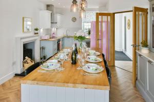 eine Küche mit einem Tisch mit Tellern und Weingläsern in der Unterkunft Seaside Luxury Escape in Aberdour