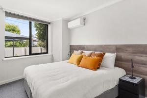 - une chambre avec un grand lit et une fenêtre dans l'établissement Boutique Stays - Lilly Pilly, à Melbourne