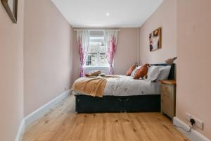 a bedroom with a bed and a window at Blacksand sea view cottage in Aberdour