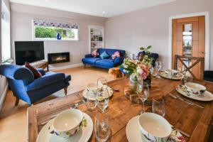 uma sala de estar com uma mesa de madeira e cadeiras azuis em Blacksand sea view cottage em Aberdour