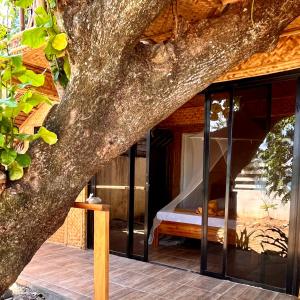 um quarto numa árvore com uma cama em Amami Beachfront Villa with Private Beach em Puerto Galera