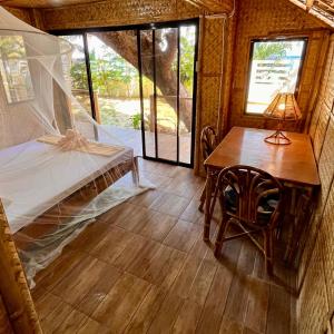 um quarto com uma cama, uma mesa e uma janela em Amami Beachfront Villa with Private Beach em Puerto Galera