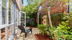una silla negra sentada en un porche con plantas en Boutique Stays - Brighton Abode, en Melbourne