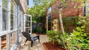 a black chair sitting on a porch with plants at Boutique Stays - Brighton Abode in Melbourne