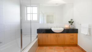 Un baño blanco con lavabo y ducha. en Boutique Stays - Brighton Abode, en Melbourne 12 fotos más