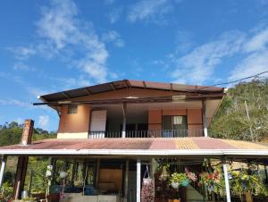 Haus mit Balkon und blauem Himmel in der Unterkunft Hospedaje Luis & Ana in Pejibaye