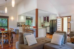 a living room with a couch and a kitchen at A Perfect Stay - Blue Bliss House and Studios in Byron Bay