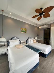a bedroom with two beds and a ceiling fan at Vườn Vua Resort & Villas in Ðồng Phú