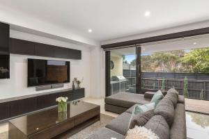 a living room with a couch and a tv at Boutique Stays - Edinburgh Place in Melbourne