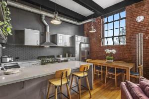 a kitchen with a counter and a table with chairs at Boutique Stays - Loft on Rose in Melbourne