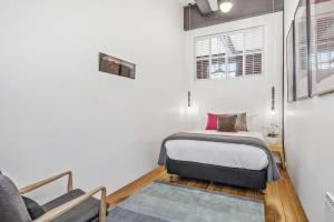 1 dormitorio pequeño con 1 cama y 1 silla en Boutique Stays - Loft on Rose, en Melbourne