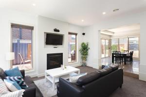 a living room with a couch and a fireplace at Boutique Stays - Mentone Abode in Mentone