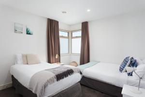 two beds in a room with a window at Boutique Stays - Mentone Abode in Mentone