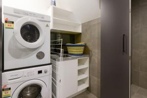 a laundry room with a washer and dryer at Boutique Stays - Victoria Road in Melbourne