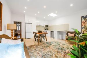 a living room and kitchen with a table and chairs at Boutique Stays - Carlton Terrace in Melbourne