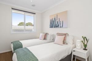 two beds in a white room with a window at Boutique Stays - The Richardson in Mentone