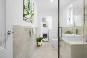 a bathroom with a sink and a washing machine at Boutique Stays - Carlton Terrace in Melbourne
