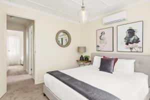 a bedroom with a large white bed and a mirror at Boutique Stays - Buckingham in Melbourne