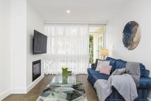 a living room with a blue couch and a fireplace at Boutique Stays - Brighton By Sea in Melbourne