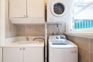 a small bathroom with a sink and a washing machine at Boutique Stays - Buckingham in Melbourne