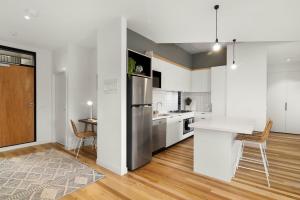 een keuken met een roestvrijstalen koelkast en een tafel bij Boutique Stays - Highviews in Melbourne