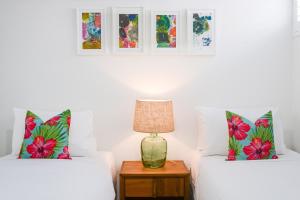 two beds in a room with a lamp on a table at Boutique Stays - Hampton Lookout in Melbourne