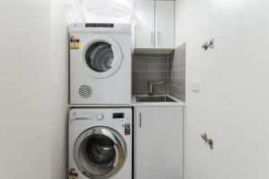 uma cozinha com uma máquina de lavar roupa e um lavatório em Boutique Stays - Hampton Lookout em Melbourne
