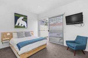 1 dormitorio con 1 cama, TV y silla en Boutique Stays - Port Haven, en Melbourne