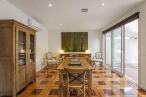 a dining room with a wooden table and chairs at Boutique Stays - Elwood Hideaway in Melbourne