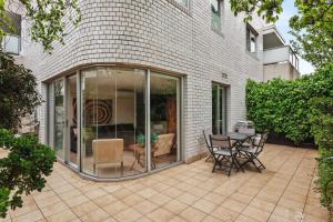 un patio con sillas y una mesa frente a un edificio en Boutique Stays - Lalique, en Melbourne