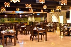 The Fern Residency, Vadgaon - Talegaon, Pune في بيون: غرفة طعام مع طاولات وكراسي في مطعم