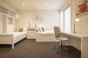 a bedroom with a bed and a desk and a chair at Boutique Stays - Elwood Hideaway in Melbourne