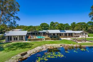 a house with a pond in front of it at A Perfect Stay - Lennox Coastal Retreat in Lennox Head