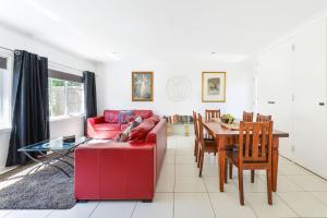 a living room with a red couch and a table at Brighton Rose in Melbourne