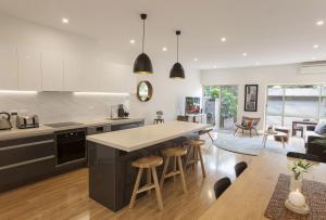 a kitchen and dining room with a table and chairs at Boutique Stays - Central Park in Melbourne