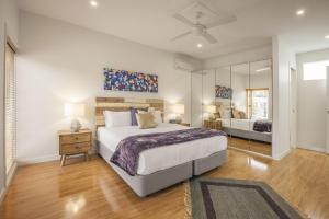 a bedroom with a large bed and a mirror at Boutique Stays - Central Park in Melbourne