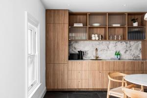 a kitchen with wooden cabinets and a table at Boutique Stays - The Vault in Melbourne