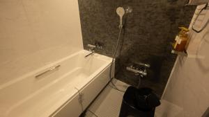 a bathroom with a white tub and a toilet at THE HOTEL YAKUSHIMA ocean & forest in Yakushima