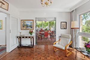 a living room with a chair and a table at Boutique Stays - That 70s House in Mount Waverley +13 photos