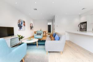 a living room with a couch and a tv at Boutique Stays - Murrumbeena Place 2 in Carnegie