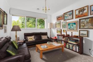 a living room with a couch and a coffee table at Boutique Stays - That 70s House in Mount Waverley