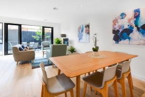 a living room with a wooden table and chairs at Boutique Stays - Murrumbeena Place 2 in Carnegie