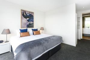 a bedroom with a large bed with blue pillows at Boutique Stays - Murrumbeena Place 2 in Carnegie