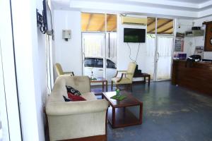 a living room with chairs and a tv and a table at Station Garden Hotel And Resturant in Jaffna