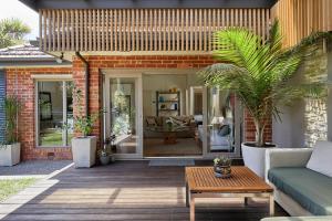 a patio with a couch and a table at Boutique Stays - Mordi Sands in Mordialloc